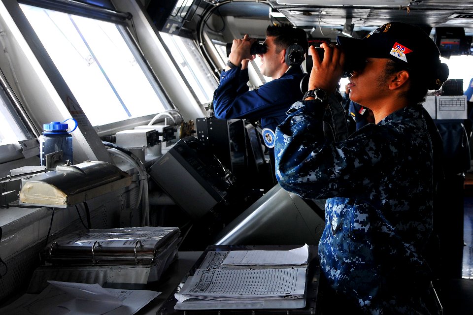 US Navy 110531-N-EE987-006 Ensign Claudia Garcasrios and Operations Specialist Seaman David Gomez scan for surface contacts on the bridge of USS Ro