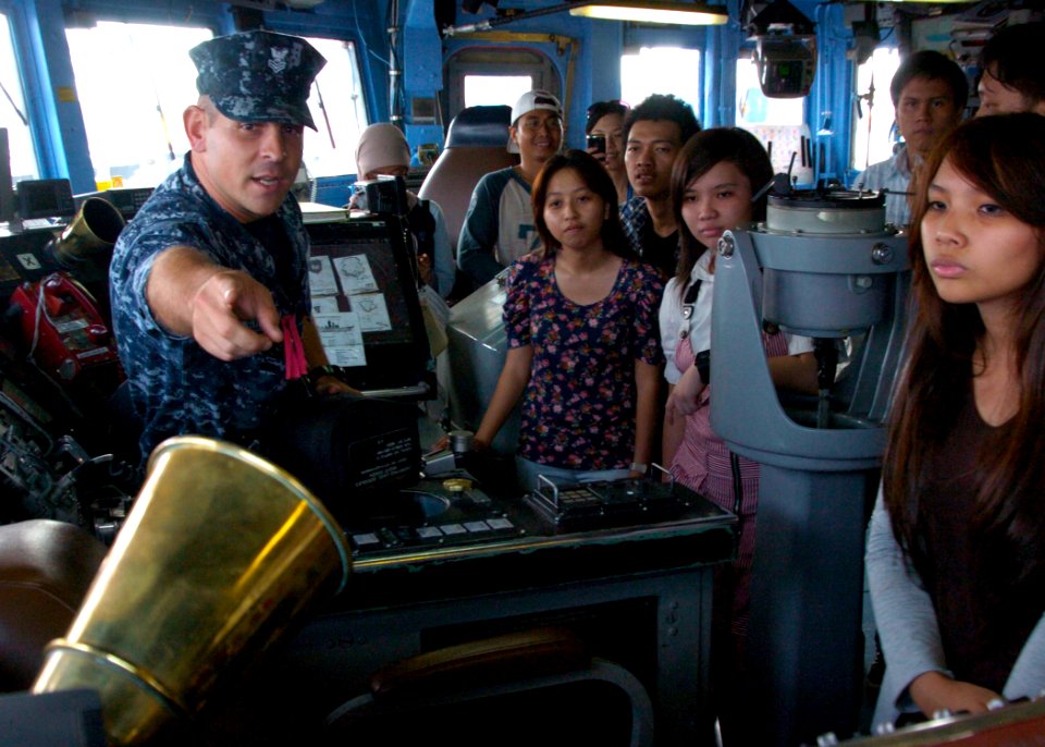 US Navy 110530-N-VY256-286 Master-at-Arms 1st Class Darryl Robertson-Dias points out equipment used in the bridge to a group of Indonesian visitors