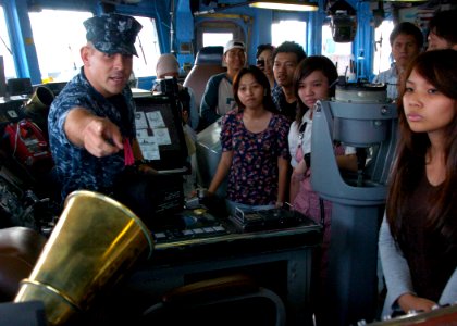 US Navy 110530-N-VY256-286 Master-at-Arms 1st Class Darryl Robertson-Dias points out equipment used in the bridge to a group of Indonesian visitors