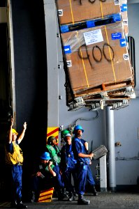 US Navy 110531-N-GL340-077 Sailors guide pallets into the hangar bay during a replenishment at sea aboard the aircraft carrier USS Ronald Reagan (C