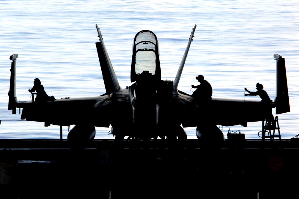 US Navy 110529-N-6006S-203 Sailors aboard the aircraft carrier USS Carl Vinson (CVN 70) work on an F-A-18 Hornet in the ship's hangar bay