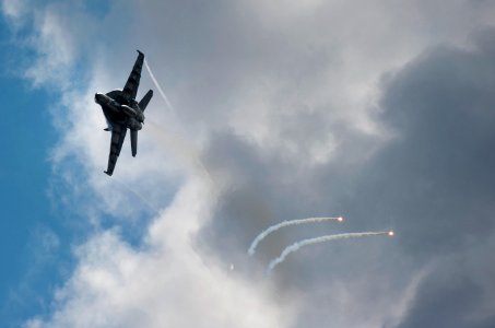 US Navy 110531-N-DR144-524 An F-A-18E Super Hornet deploys flares alongside USS Carl Vinson (CVN 70) during an air power demonstration