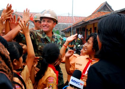 US Navy 110526-N-KK935-491 Builder 1st Class Chris Louden, assigned to Amphibious Construction Battalion (ACB) 1, high-fives children at Ciangsana