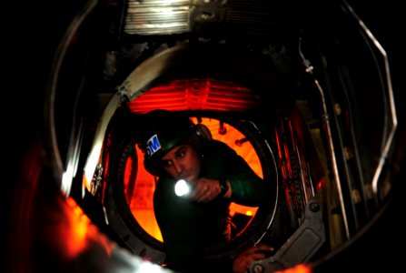 US Navy 110527-N-GC412-026 Aviation Structural Mechanic 1st Class Georlando Alvarez, from Miami, Fla., inspects the engine of an E-2C Hawkeye aboar