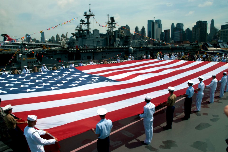 US Navy 110530-N-1251W-103 Service members unfurl an American Flag on the flight deck of the Intrepid Sea, Air ^ Space Museum during a Fleet Week N