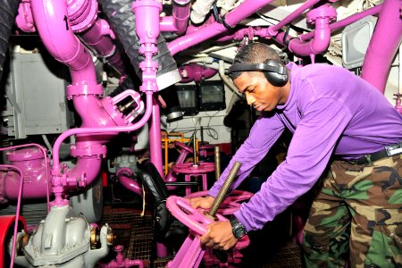 US Navy 110529-N-OP638-006 Aviation Boatswain's Mate (Fuel) 3rd Class Antoine Kirk secures the valve to a fuel pipe aboard the aircraft carrier USS