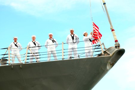 US Navy 110601-N-KT462-580 A Sailor lowers the Navy Jack while getting underway aboard USS Chung Hoon (DDG 93)