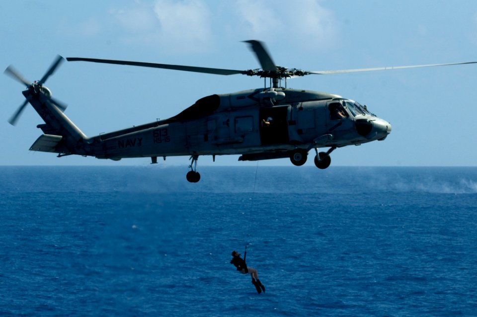 US Navy 110603-N-MD252-393 A search and rescue swimmer is deployed from an SH-60F Sea Hawk helicopter during an air power demonstration over USS Ca