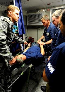 US Navy 110531-N-BA263-030 Royal Australian Navy Lt. Cmdr. Joel Hissink, left, examines a patient while Israeli navy Lt. Cmdr. Roneu Bar and Capt
