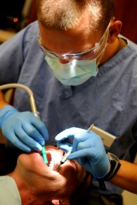 US Navy 110603-N-AW868-107 Hospital Corpsman 3rd Class Steven Wade performs an annual teeth cleaning on Senior Chief Intelligence Specialist Willia photo