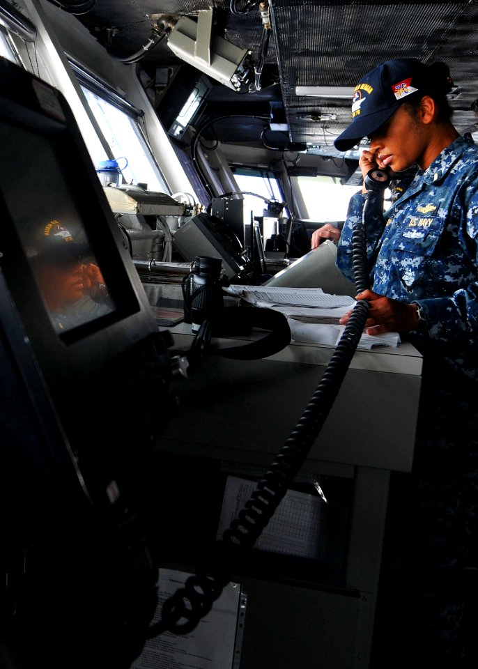 US Navy 110531-N-EE987-016 Ensign Claudia Garcasrios ses an integrated voice user telephone (IVUT) to relay a message to USS Chancellorsville (CG 6