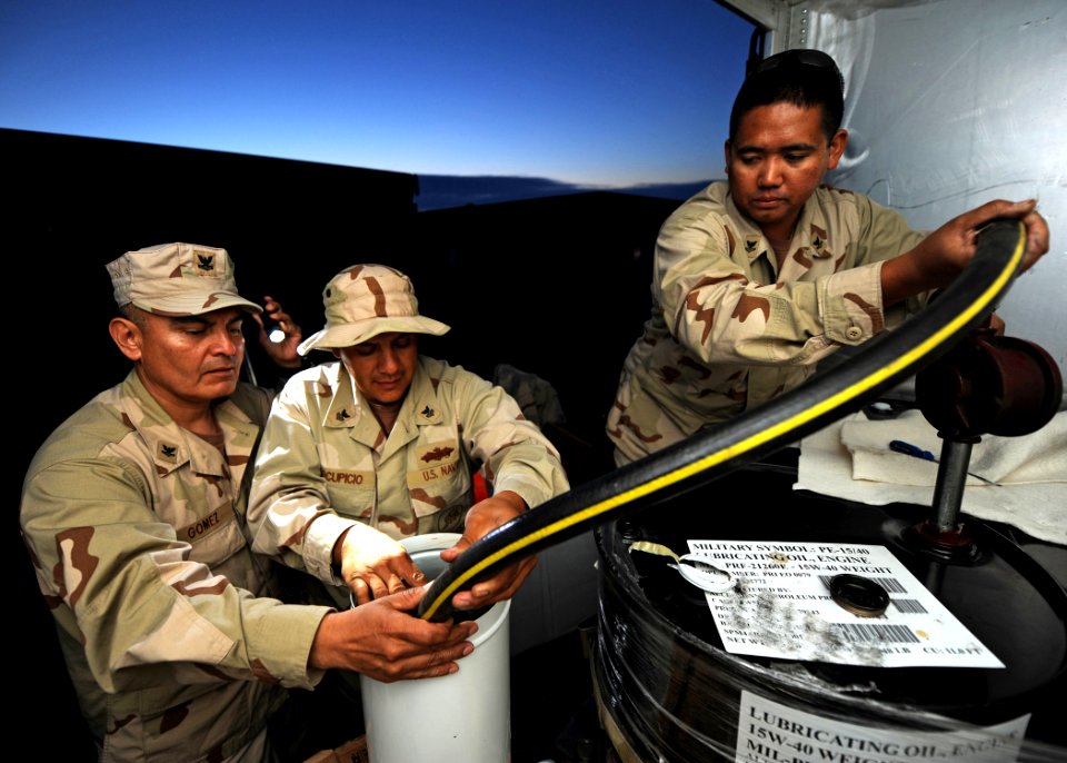 US Navy 110604-N-PM781-069 Sailors assigned to Maritime Expeditionary Security Squadron (MSRON) 1, pump lube oil for their camp generator