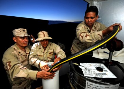 US Navy 110604-N-PM781-069 Sailors assigned to Maritime Expeditionary Security Squadron (MSRON) 1, pump lube oil for their camp generator
