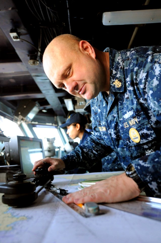 US Navy 110531-N-XE109-013 Command Master Chief David Colton demonstrates how to plot points on a map aboard the aircraft carrier USS George H.W. B