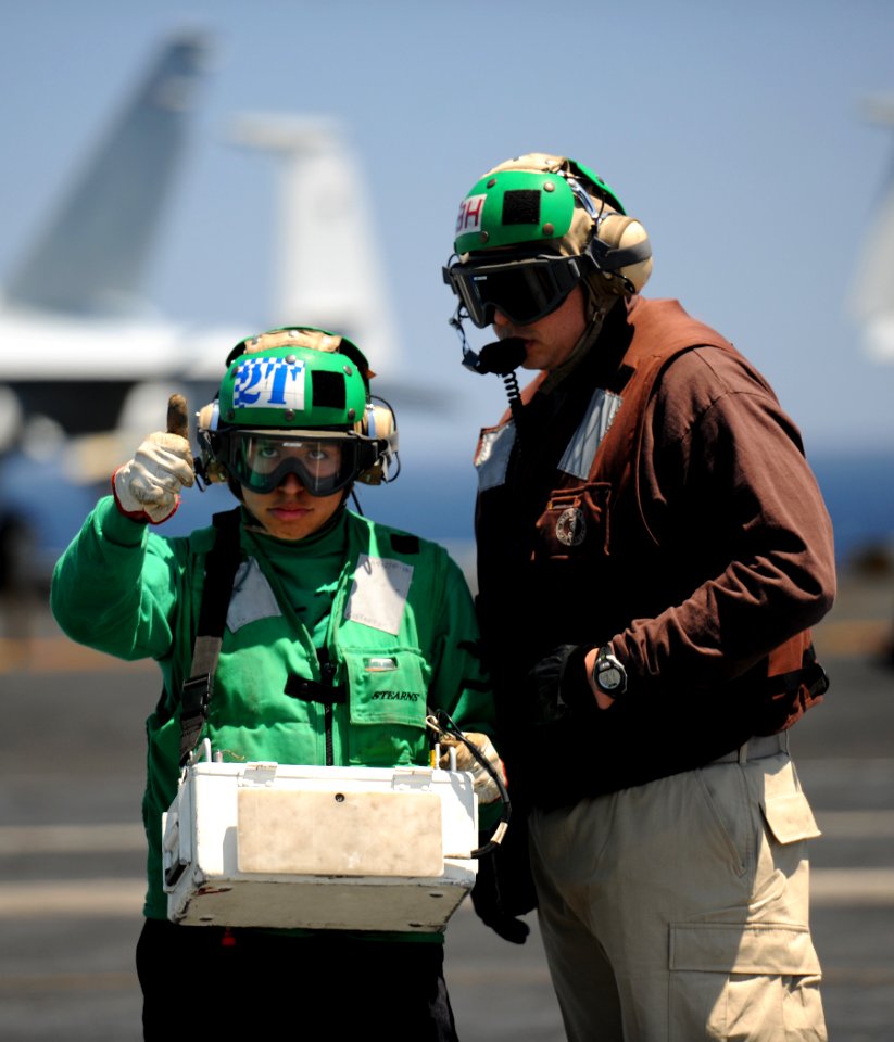 US Navy 110602-N-YZ751-429 A Sailor signals to a pilot aboard USS George H.W. Bush (CVN 77)