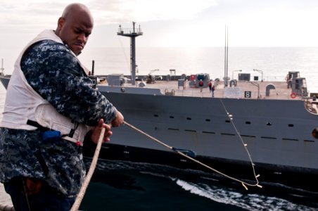 US Navy 110606-N-BT887-004 Boatswain's Mate 2nd Class Zack Scott, from Mt. Sterling, Ky., feeds a line to the Military Sealift Command fleet replen