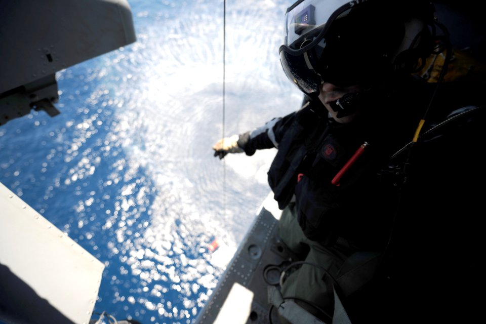 US Navy 110602-N-YZ751-075 Naval Air Crewmen 3rd Class Stuart Thompson lowers a rescue basket from an MH-60S Sea Hawk helicopter during search and