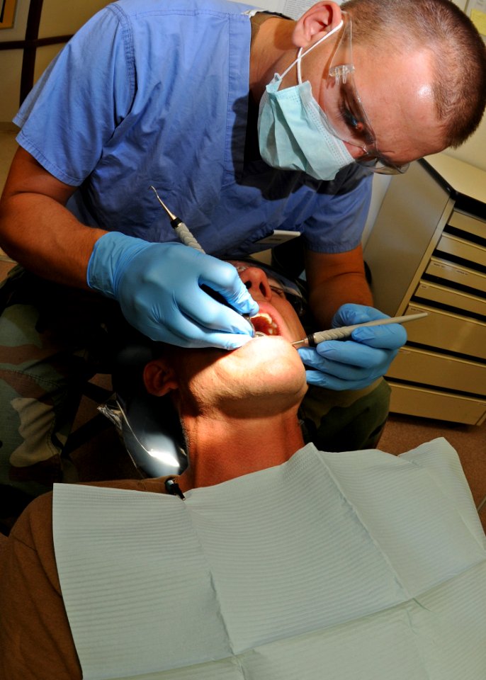 US Navy 110603-N-AW868-037 Hospital Corpsman 3rd Class Steven Wade performs an annual teeth cleaning on Senior Chief Intelligence Specialist Willia