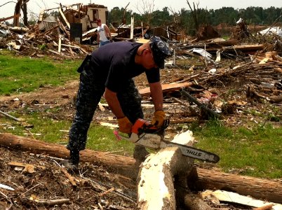 US Navy 110602-N-ZZ999-003 Chief Yeoman Mike Shea, assigned to the Virginia-class attack submarine USS Missouri (SSN 780), helps remove downed tree