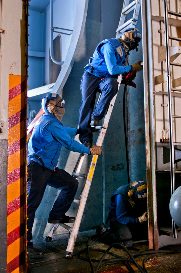 US Navy 110605-N-BT887-006 Sailors perform maintenance on deck edge doors of the Nimitz-class aircraft carrier USS John C. Stennis (CVN 74)