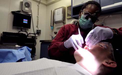 US Navy 110603-N-JD217-041 Aviation Structural Mechanic 3rd Class Marcella Scott performs a dental exam aboard USS George H.W. Bush (CVN 77)