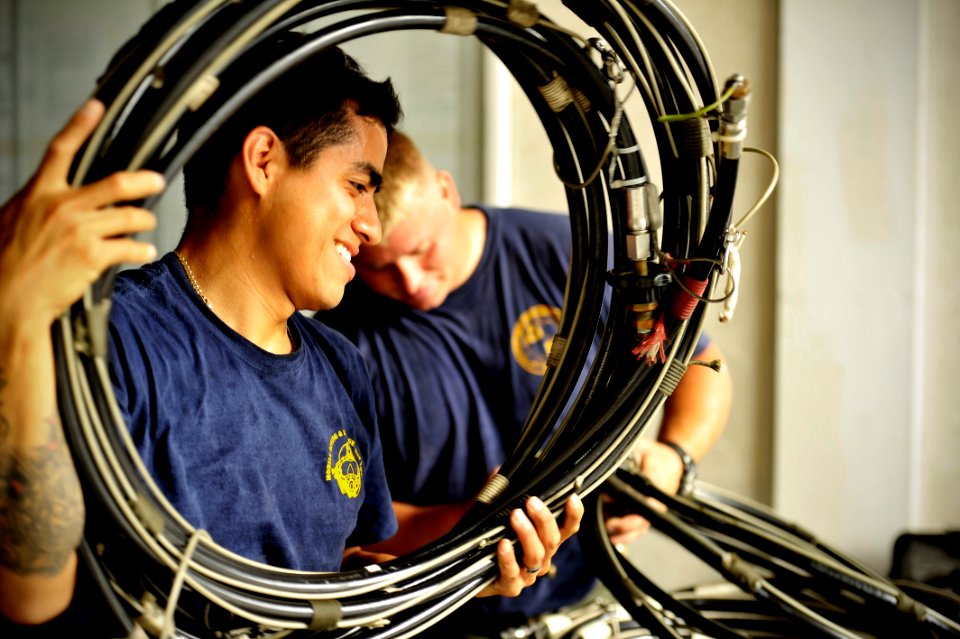 US Navy 110606-N-KB666-196 Navy Diver 1st Class Jimmy Sotelo, assigned to Mobile Dive and Salvage Unit (MDSU) 2, sets up high-pressure hoses for th
