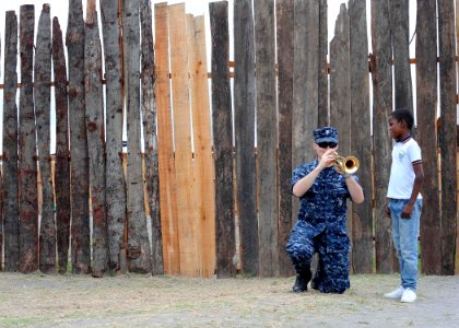 US Navy 110606-F-ET173-050 Musician 3rd Class Steve Freeman, from Austin, Texas, plays a trumpet for a Colombian boy before a concert at Institucio photo