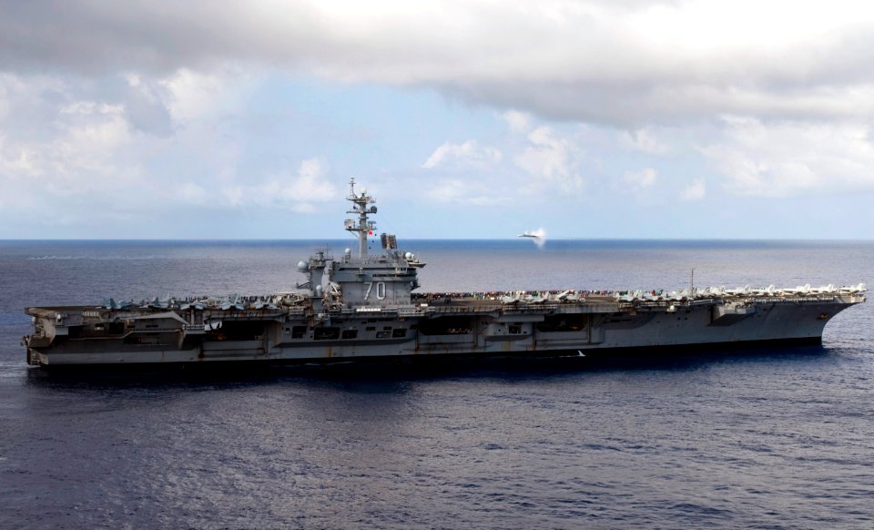 US Navy 110606-N-GZ277-066 An F-A18C Hornet breaks the sound barrier over the Nimitz-class aircraft carrier USS Carl Vinson (CVN 70) during an air