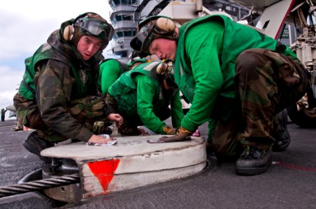 US Navy 110607-N-BT887-002 Sailors clean a retractable sheave on the flight deck of the Nimitz-class aircraft carrier USS John C. Stennis (CVN 74)