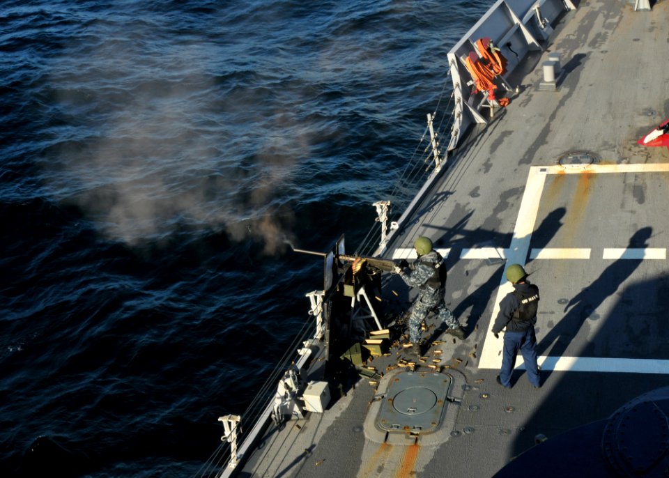 US Navy 110606-N-NL541-090 Seaman Michael Trusik mans a .50 caliber machine gun while Logistics Specialist 3rd Class Mickey Thiele maintains radio