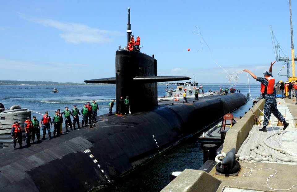 US Navy 110608-N-GU530-161 A Sailor throws a heaving line to line handlers aboard the Ohio-class guided-missile submarine USS Michigan (SSGN 727) a