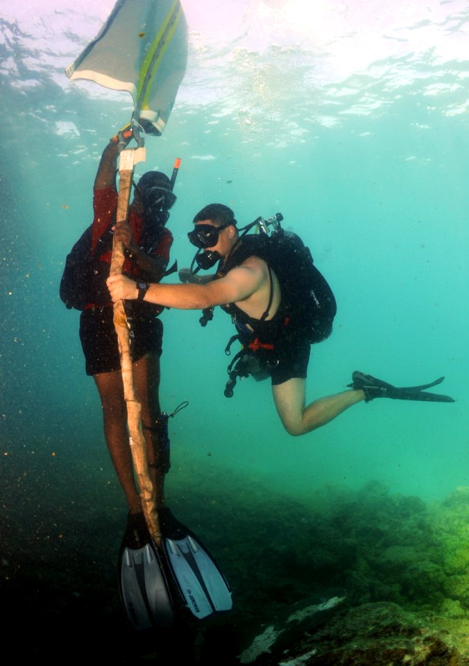 US Navy 110608-N-XD935-079 Navy Diver 2nd Class Justin McMillen holds the lift line as Ordinary Seaman Romando Thomas fills air into a lift bag