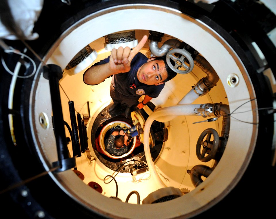 US Navy 110607-N-EC642-488 Machinist's Mate 2nd Class Joel Rivera, right, assigned to Deep Submergence Unit, directs members of the media down the