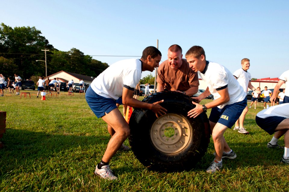 US Navy 110606-N-MR305-037 Capt. Eric Jabs, assigned to Navy Expeditionary Combat Command, and two U.S. Naval Academy Midshipmen flip a truck tire