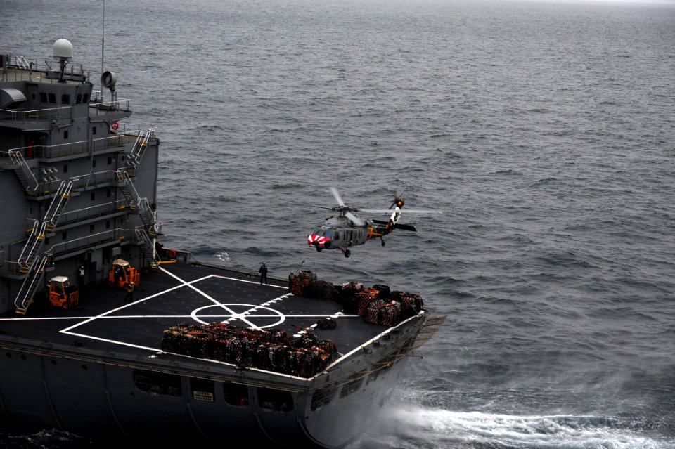 US Navy 110609-N-OI955-230 An MH-60S Sea Hawk helicopter performs a vertical replenishment between SNS Guadalupe (T-AO 200) and USS John C. Stennis
