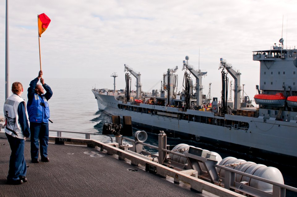 US Navy 110606-N-BT887-001 Quartermaster Seaman Apprentice Brittney Solomon, from Albany, Ga., carries the Oscar flag during a replenishment at sea