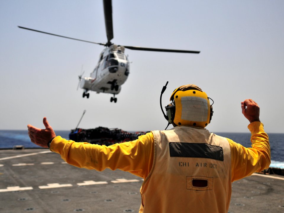 US Navy 110606-N-ZS026-008 Civilian helicopter engineer Sam Russell signals a 330J Puma helicopter to land aboard the Military Sealift Command dry
