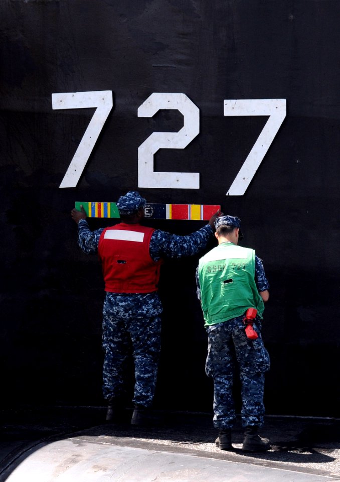 US Navy 110608-N-GU530-182 Sailors assigned to the Blue Crew of the Ohio-class guided-missile submarine USS Michigan (SSGN 727) attach Michigan's h