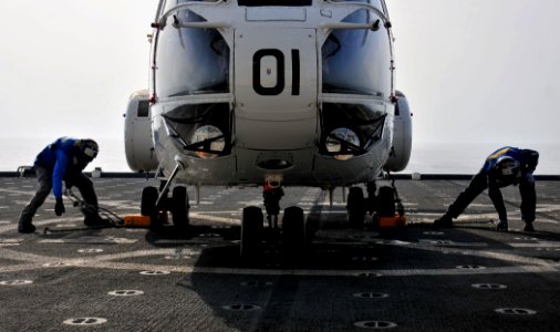 US Navy 110609-N-ZS026-001 Civilian mariners Larcia Rozvel, left, and Delbert Desparrois remove tie-down chains and wheel chocks from a 330J Puma h