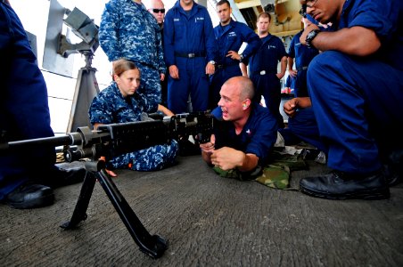 US Navy 110608-N-RC734-139 Fire Controlman 2nd Class Colin Roberts, center, gives familiarization training on the M240 machine gun during a live-fi