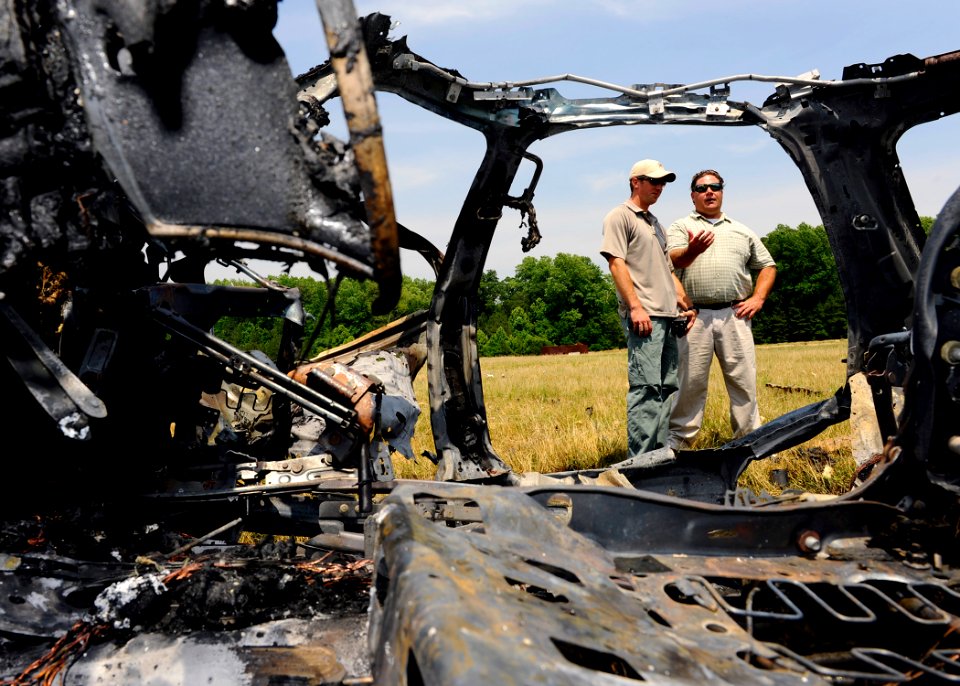 US Navy 110607-N-ZZ999-092 Lt. Joe Clunie, left, and Retired Damage Controlman 1st Class John Frush talk about the damage to a vehicle and the surr