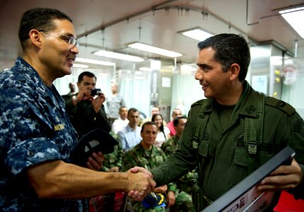 US Navy 110610-N-RM525-293 Commodore Brian Nickerson shakes hands with a Colombian military service member after presenting him with a gift at the photo