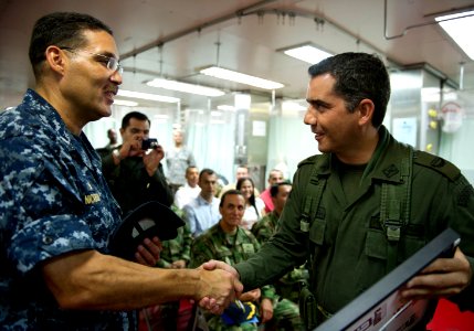 US Navy 110610-N-RM525-293 Commodore Brian Nickerson shakes hands with a Colombian military service member after presenting him with a gift at the