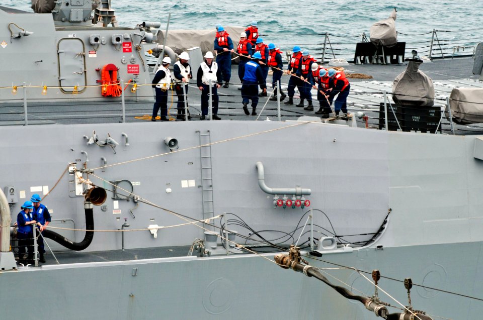 US Navy 110609-N-BT887-538 Sailors aboard the guided-missile destroyer USS Dewey (DDG 105) heave a fuel line from the Nimitz-class aircraft carrier