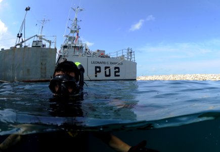 US Navy 110607-N-XD935-195 Navy Diver 1st Class Jimmy Sotelo snorkels on the surface monitoring multinational divers below conducting diving operat