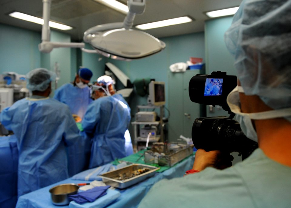 US Navy 110608-N-NY820-062 Colombian media film as doctors remove a bullet from a 23-year-old Colombian woman's cheek during a Continuing Promise 2