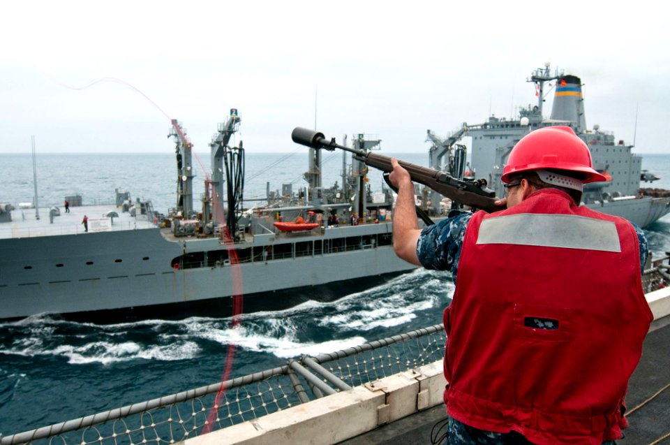 US Navy 110609-N-BT887-086 Aviation Ordnanceman Christopher Marquez, from Yuma, Ariz., fires a line from the Nimitz-class aircraft carrier USS John