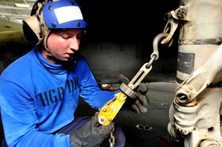 US Navy 110608-N-EE987-010 Aviation Boatswain's Mate Airman Chad Sjothun, from Keizer, Ore., chains an F-A-18C Hornet to the deck