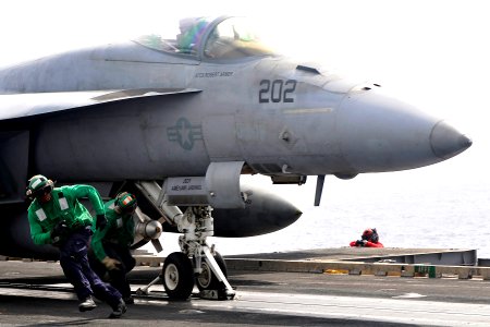 US Navy 110611-N-EE987-913 Aviation Boatswain's Mates run to safety after attaching a launch bar to an F-A-18E Super Hornet assigned to the Argonau