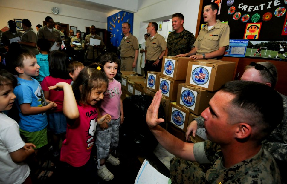 US Navy 110608-N-AQ172-341 Maj. Todd Schunks high-fives a girl from the Constanta Kindergarden ^46 class during a community service project provide